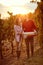 Autumn harvest grapes. man and woman winemakers walking in between rows of vines