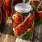 Autumn harvest of red tomatoes, horseradish and garlic in jars for preservation