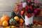 Autumn  home still life. Pumpkins and a bouquet of autumn flowers on a wooden background