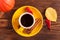 Autumn horizontal banner with yellow, red leaves, pumpkins, cup of coffee and guelder rose on brown wooden background.