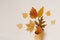 Autumn ice cream with fallen yellow leaves in a waffle Cup on a beige background. Autumn menu concept