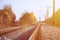 Autumn industrial landscape. Railway receding into the distance among green and yellow autumn tree