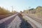 Autumn industrial landscape. Railway receding into the distance among green and yellow autumn trees