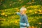 Autumn kid, cute child with fallen leaves in park. Fall leaves children concept, autumnal mood.