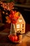 Autumn Kitchen decoration - luminous cardboard house, candle, bouquet with autumn leaves, persimmon