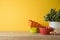 Autumn kitchen interior background with plant and colorful bowls on wooden shelf