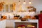 Autumn kitchen interior. Red and yellow leaves and flowers in the vase and pumpkin on light background