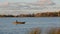 Autumn lake and lonely boat with fisherman