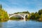 Autumn landscape of bridge with moving passenger train and Kymijoki river waters in Finland, Kouvola, Koria