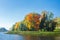 Autumn landscape of colorful trees on lakeside on sunny bright day