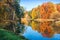 Autumn landscape with colorful trees and reflections in the water of a pond in Tsaritsyno park in Moscow