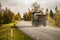 Autumn landscape of country-road with driving truck