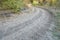 Autumn landscape with a curved road and traces of the tread of large wheels of agricultural machinery