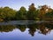 Autumn landscape with foliage reflected on a calm pond water surface