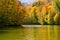 Autumn landscape with forests and a lake. Dense colorful autumn forest and mountain lake. Welcome to autumn