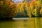 Autumn landscape with forests and a lake. Dense colorful autumn forest and mountain lake. Welcome to autumn
