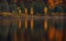 Autumn Landscape With Four Birches With Yellow Foliage And Their Beautiful Colored Reflection In The Still Water Of A Small Mounta