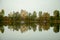 Autumn landscape. Lake, trees and village by the lake. Calm. Perfect reflection in the water.