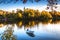 Autumn Landscape with A Lone Boat, Colorful Trees and Houses Reflected in Lake