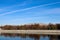 Autumn landscape with Moscow river and Luzhniki stadium in october sunny mornig with blue sky and airplane contrail