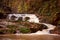 autumn landscape with mountain river and silky waterfall