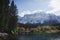 Autumn landscape of mountains covered in snow and reflected in blue lake.