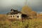 Autumn landscape with an old ruined wooden house. Old house in a field in the village on a Sunny day