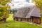 Autumn landscape with orange colored tree and wooden cottages