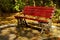 Autumn landscape. Red bench and colored leaves in a park. Tranquility. Autumn background