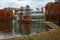 Autumn landscape with reddish trees, a glass building and a lake