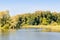 Autumn landscape with river Bank, yellowing forest and blue sky