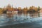 Autumn landscape by the river with ducks, background are autumn trees in the city park