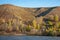 Autumn landscape,  river, windy weather, dark blue water, yellow-red autumn leaves on trees, last warm days