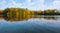 Autumn landscape. Trees, lake and cloudy. Calm. Colorful trees on a bank or lake or river.