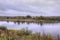 Autumn landscape. The Tura river and a lonely old wooden house on the opposite Bank