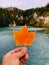 Autumn leaf in hand over Gypsum Mine Lake Cape Breton.