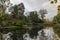 Autumn leaves color a garden with lake and bridge