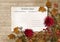 Autumn leaves and dahlias with postcard on vintage background