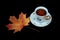 Autumn leaves of different colors, near a beautiful cup with tea.