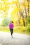 Autumn lifestyle woman running in fall forest