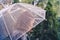 Autumn. Lonely redhead girl under a transparent umbrella with rain drops walking in a park, garden. Rainy day landscape.