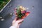 Autumn mini bouquet of yellow and orange flowers, red berries and leaves in woman hand.