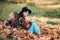 Autumn mood. Couple dreaming girls holding cup of hot tea or juice. Cheerful smiling woman with sister sitting on fall