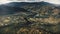 Autumn mountain forest above town aerial view. Cityscape streets, road. Buildings at river. Cottages