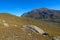 Autumn mountain landscape. The slopes are covered with yellowish dry grass and huge boulders