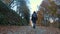 Autumn in the mountains. A girl, a hiker with a backpack, walks through the autumn forest in the Alps, Italy. Active