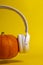 Autumn music concept. Orange pumpkin with headphones on yellow background.