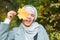 Autumn muslim woman holding maple leaf outdoors in sunny day. Beautiful arab wearing hijab girl in fall park