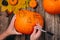 Autumn mystery. Halloween decoration concept. Close up hands with pumpkin on wooden vintage table. Draw make a draft on