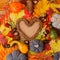 Autumn natural organic background. Vibrant color red orange yellow foliage leaves on beige background and heart shaped wreath with